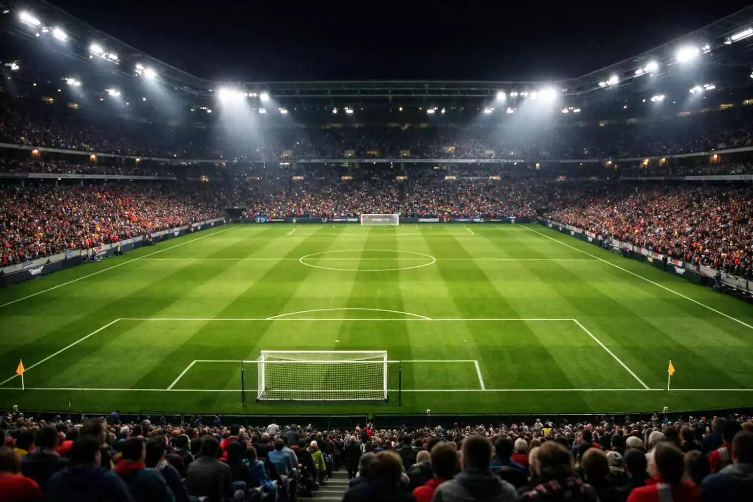 Fußballstadion der Bundesliga bei Flutlicht mit grünem Rasen und gefüllten Rängen
